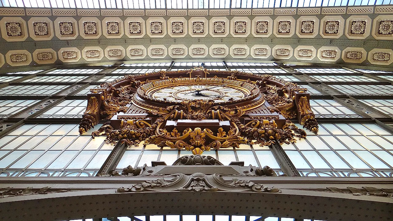 One of the great glass clocks of the Musée d'Orsay, set in an ornate gilded frame against the glass roof of the former station.