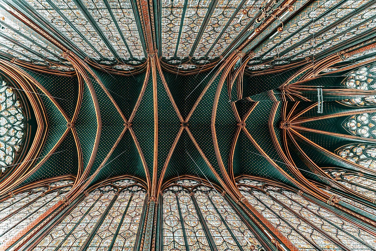 The vault of the Sainte-Chapelle seen from below, in green and gold, with the stained-glass windows rising on both sides.